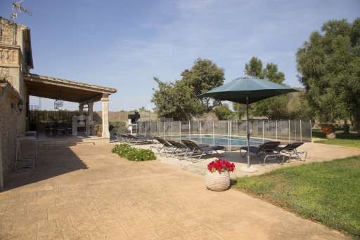 Finca Perrotti Manacor, umzäunter Pool, Haus, Garten, überdachte Terrasse, Sonnenliege, Sonnenschirm